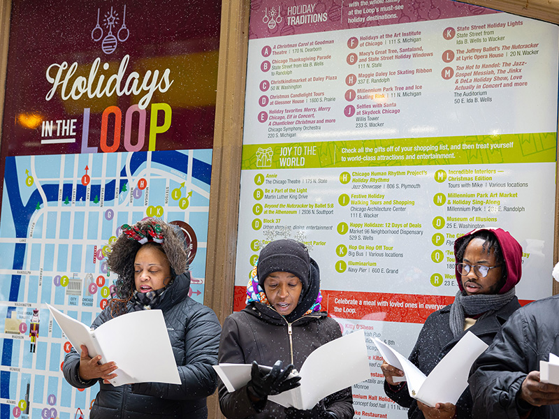 Four Carolers in front of Holidays in the Loop Kiosk